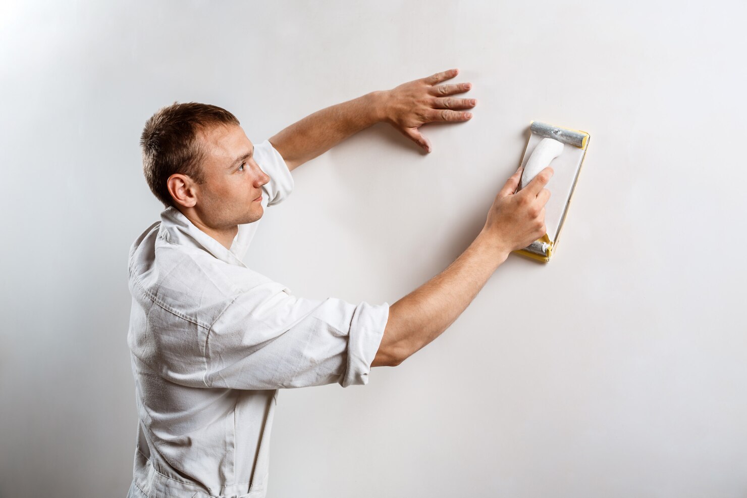 worker grinding white wall with sandpaper 176420 4753